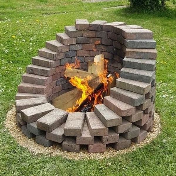 a fire pit made out of bricks in the grass