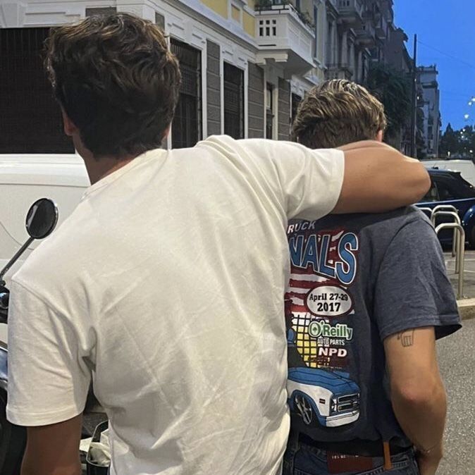 two men standing next to each other on the street