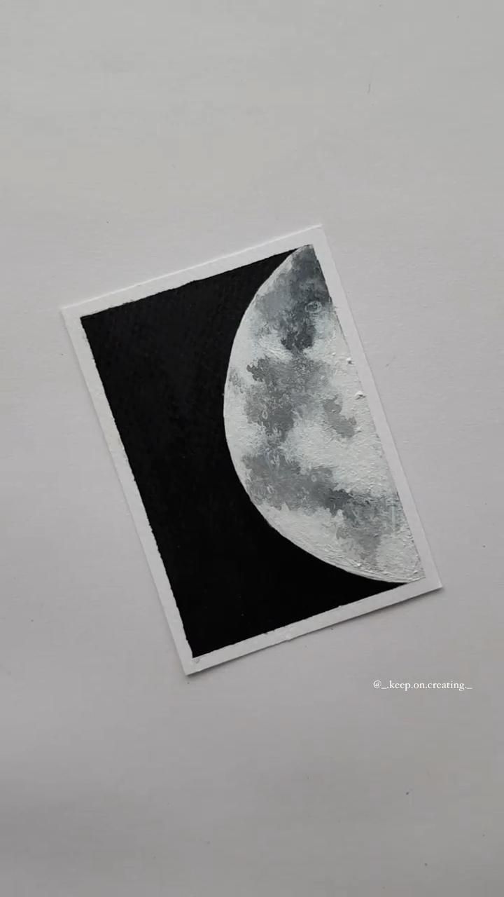 a black and white photo of the moon on a gray wall with clouds in the sky