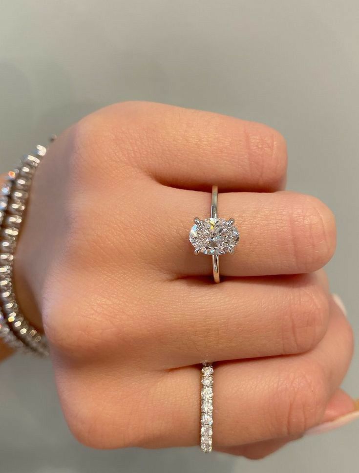 a woman's hand holding a diamond ring