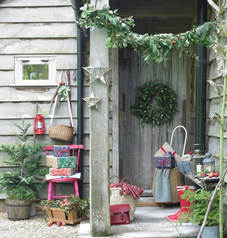 an outdoor garden with potted plants and hanging baskets on the side of a building