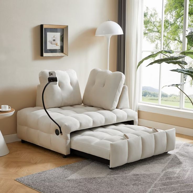 a living room with a white couch and lamp on the floor next to a window