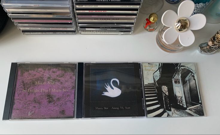 four cd cases sitting on top of a white table