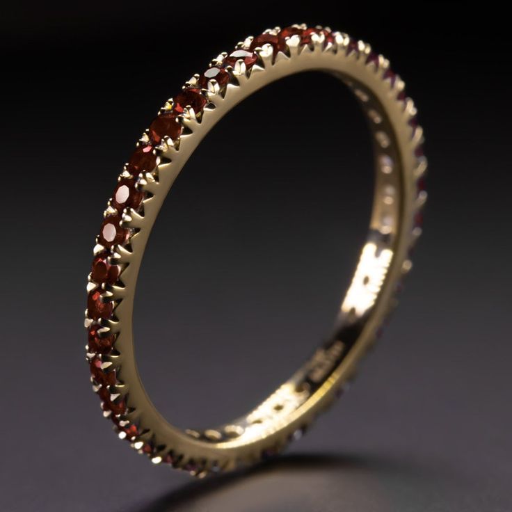 Why we love it: This garnet band has a classic design with rich red garnets continuing all the way around the band! It is a great choice for a wedding band or a stand alone piece. Highlights: - 0.70 carat of natural garnets - Full eternity design - Solid 14k yellow gold setting Dimensions: The ring measures 1.9mm across (north south) and 2.0mm from finger to top Sizing: As an eternity ring, this can't be easily resized. It is only available in size 5.5, 6.5, and 8.0. Additional Notes: This is pa Garnet Eternity Ring, Elegant Red Stackable Eternity Band, Elegant Ruby Eternity Band In Yellow Gold, Elegant Yellow Gold Ruby Eternity Band, Elegant Red Ruby Eternity Band, Ruby Eternity Band In Yellow Gold Stackable, Yellow Gold Ruby Eternity Band Stackable, Stackable Ruby Eternity Band In Yellow Gold, Classic Ruby Eternity Band For Formal Occasions