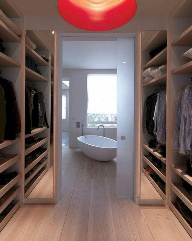 an open closet with a tub and clothes on shelves