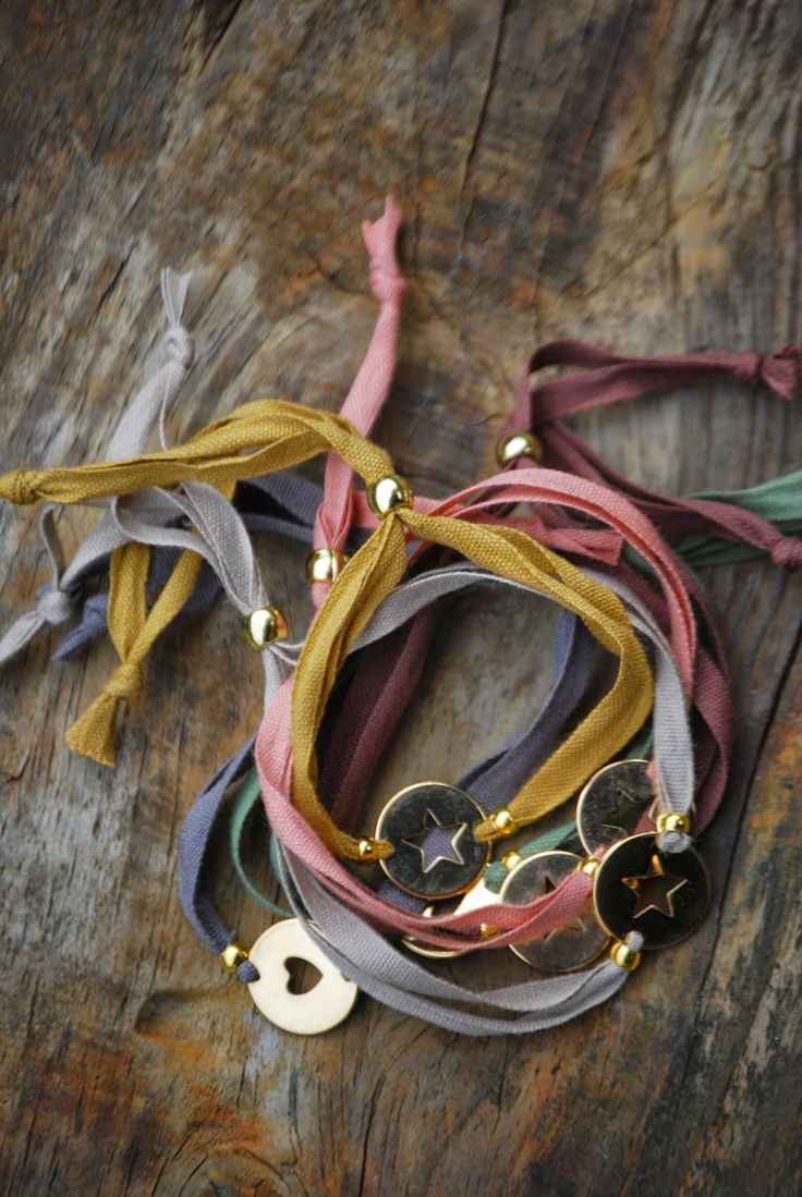 several different colored ties on top of a wooden table next to a keychain