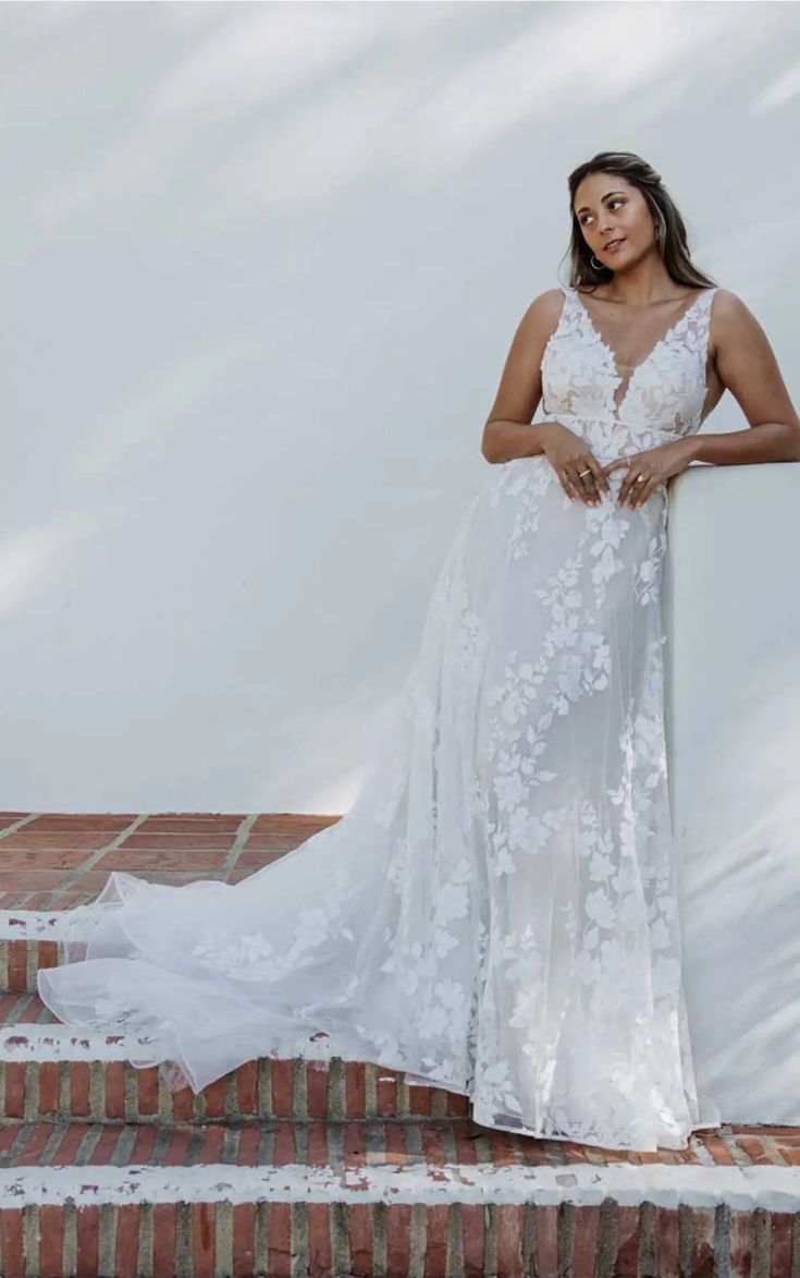 a woman in a white dress standing on some steps