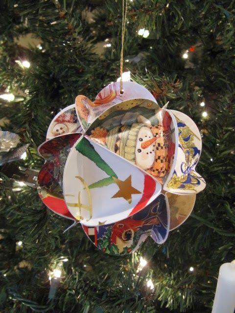 an ornament hanging from a christmas tree decorated with plates and other things in it