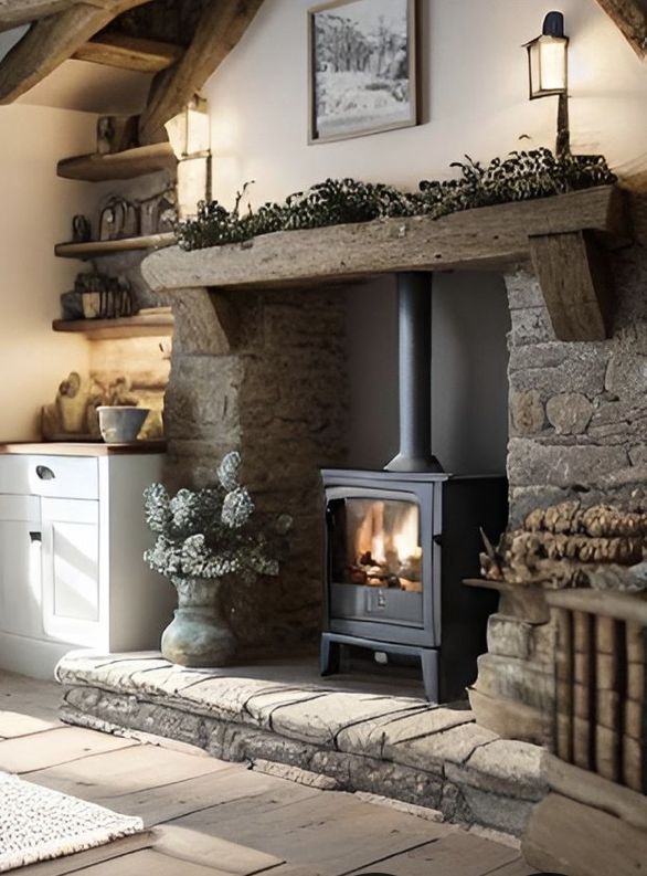 a fireplace in a living room next to a stone wall and wooden flooring with potted plants on the mantle