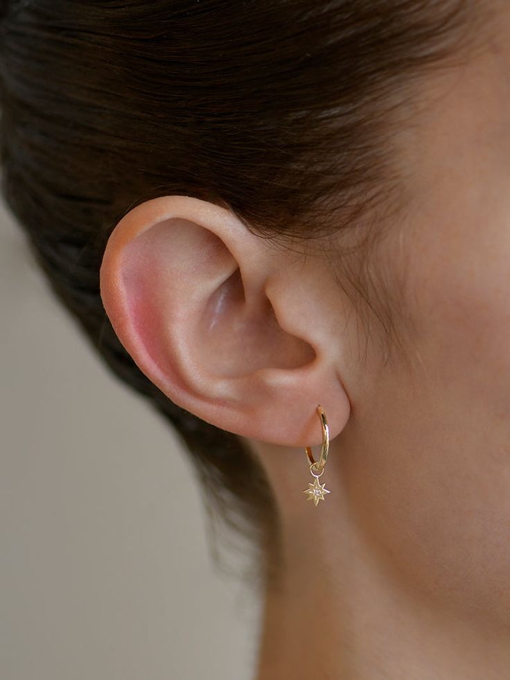 Delicate icon star charms set with a diamond center are suspended from a yellow gold clicker hoop.Inspired by her love of creating unique yet wearable ear stacks, the Anzie X Mel Soldera collection is designed for easy and effortless wear, and is modern and chic with some fun twists that reflect Melissa's personal style. Diamonds measure 1mm Diamond carat weight 0.01ct Hoops measure 14mm in diameter 14k yellow gold Sold as a pair Designed by Anzie Everyday Star-shaped Yellow Gold Jewelry, Everyday Yellow Gold Star Jewelry, Everyday Yellow Gold Earrings With Star Charm, Celestial Single Earring For Everyday Wear, Everyday 14k Gold Jewelry With Star Charm, Everyday 14k Gold Star Jewelry, Celestial Star Charm Earrings For Everyday, Everyday Celestial Earrings With Star Charm, Minimalist Yellow Gold Hoop Earrings With Charms