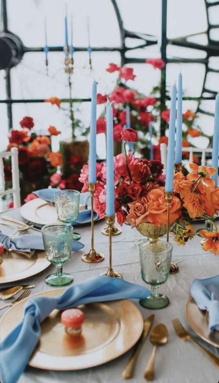 Maximalist Wedding Table Decor, Red Orange Pink Blue Wedding, Vibrant Wedding Table Decor, Blue Wedding Colour Scheme, Red Orange Blue Wedding, Wedding Blue Orange, Orange And Blue Table Setting, Unique Floral Centerpieces, Blue And Orange Table Setting