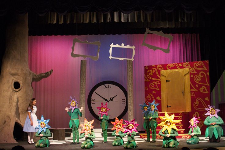 the children are performing on stage in their costumes