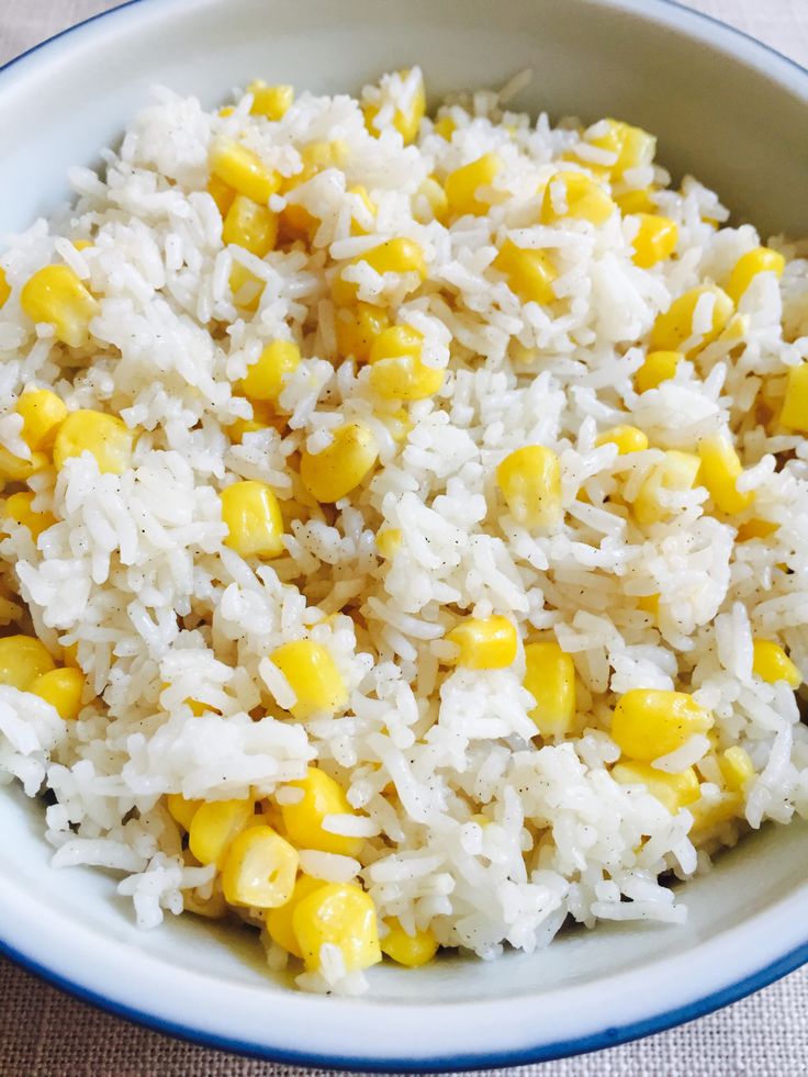 a bowl filled with rice and corn on top of a table