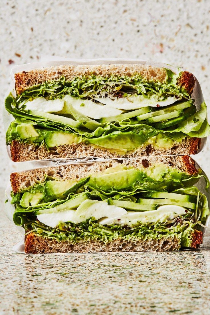 two sandwiches stacked on top of each other with lettuce and mayonnaise