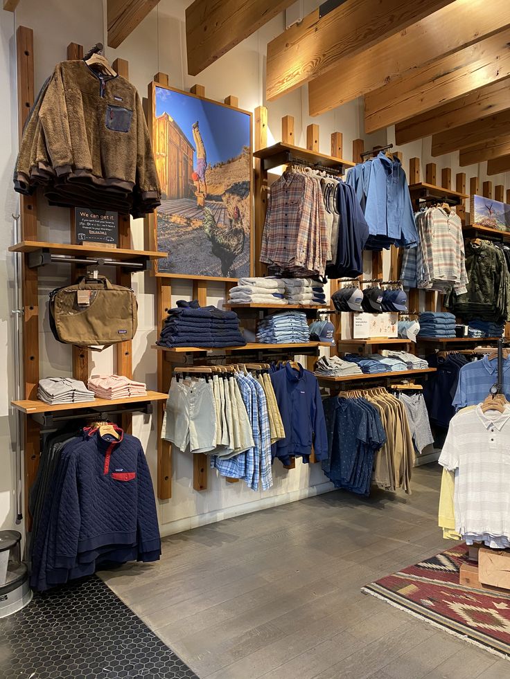 a store filled with lots of clothing on wooden shelves