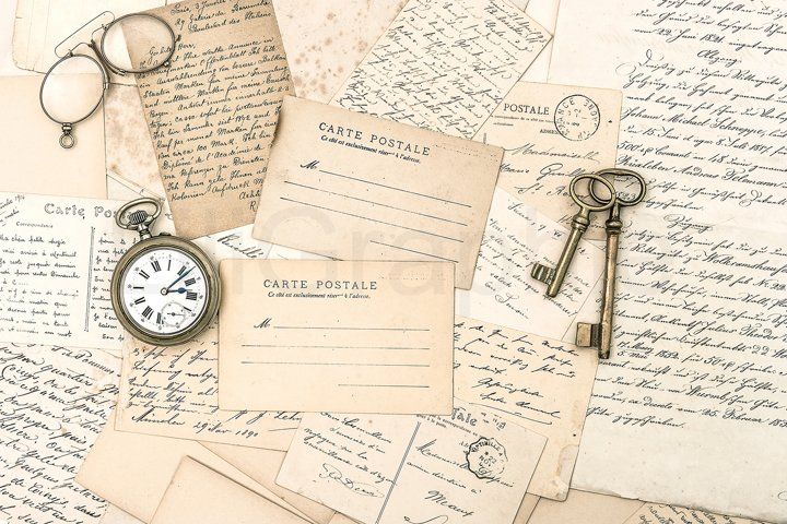 an old time pocket watch and keys on top of letters