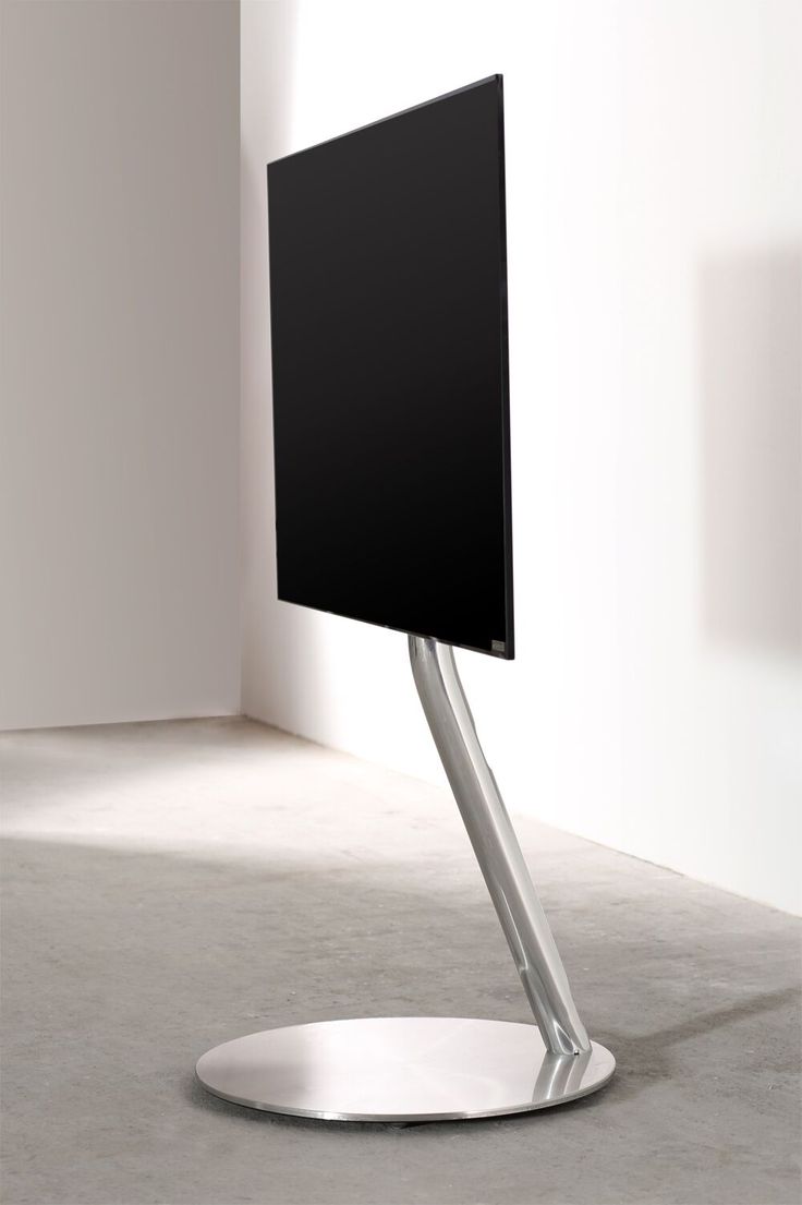 a flat screen tv sitting on top of a metal stand in front of a white wall