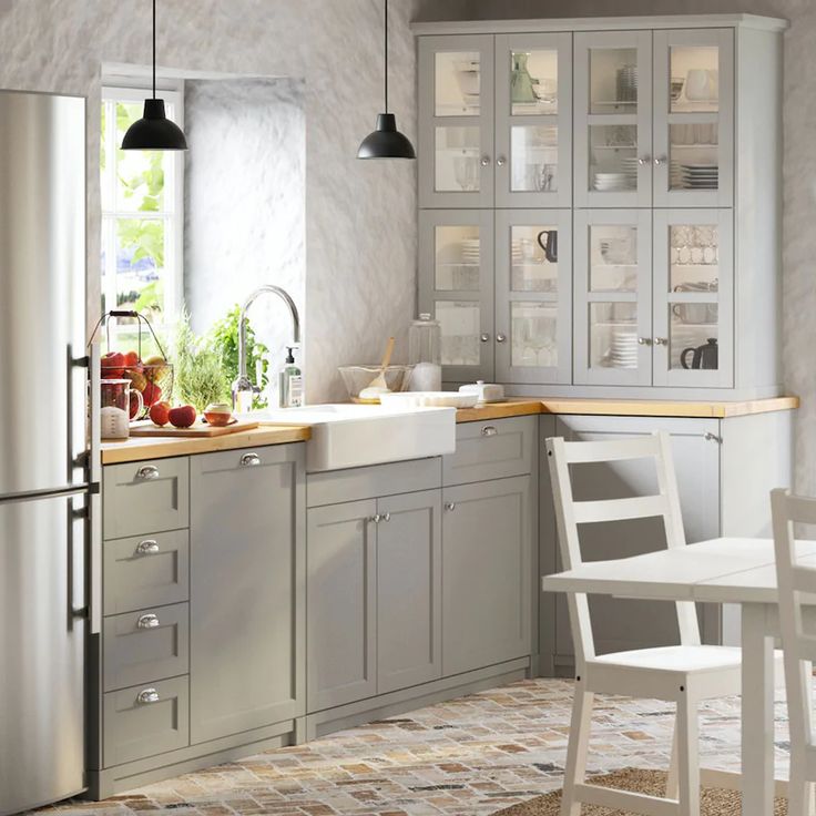 a kitchen with gray cabinets and white chairs