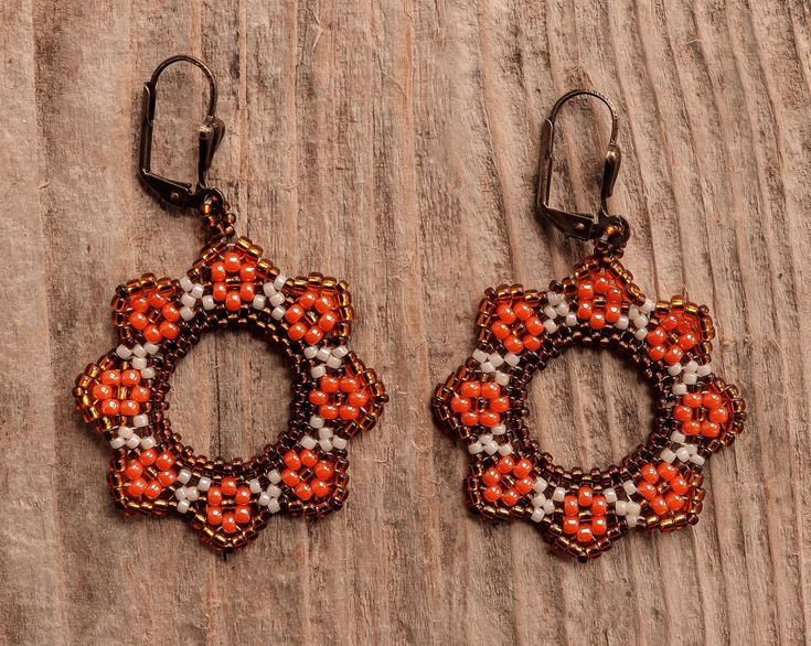 these earrings are characterized by a circular shape that recalls the shape of flowers. The main colour is orange and from here the name sunset flower Orange Beaded Flower Earrings, Orange Flower-shaped Earrings For Gift, Handmade Orange Circular Earrings, Handmade Orange Flower-shaped Jewelry, Handmade Orange Flower Earrings, Orange Circular Jewelry As A Gift, Handmade Orange Flower Shaped Earrings, Bohemian Orange Round Hoop Earrings, Orange Circular Jewelry Gift