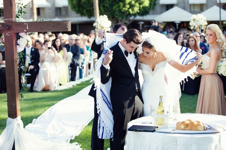 a newly married couple standing in front of a crowd