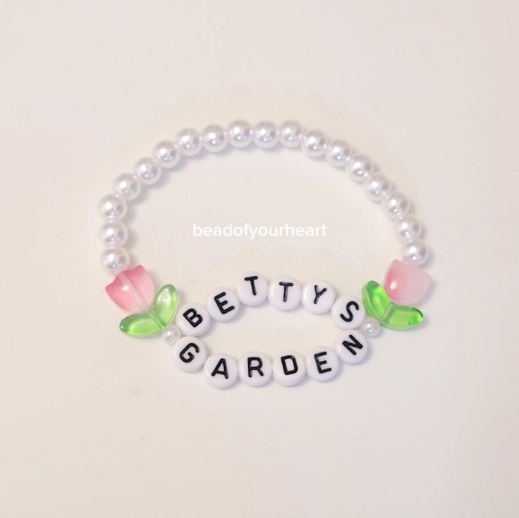 the beaded bracelet is decorated with flowers and letters that spell out betty's garden