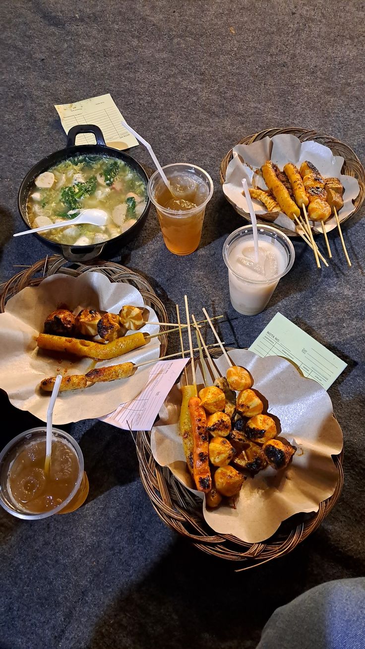 several baskets filled with food sitting on top of a table next to cups and sauces