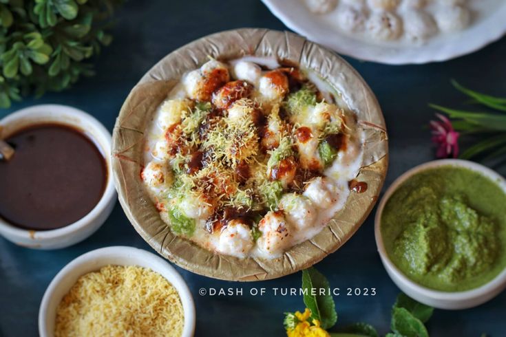 several different types of food on plates with dipping sauces