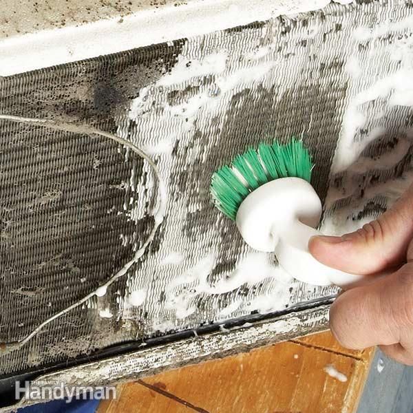 a person is using a brush to clean the window sill with foam on it