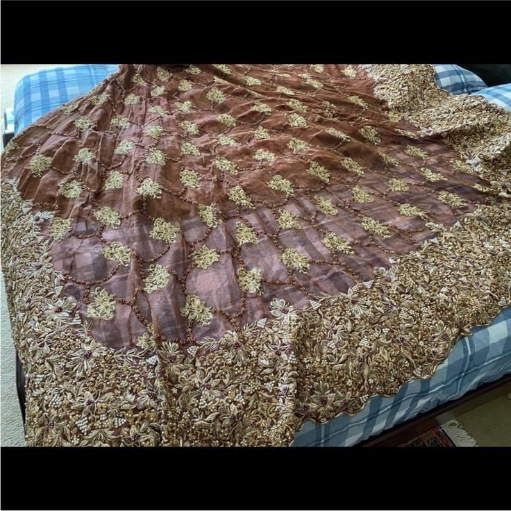 a bed with a brown and gold bedspread on it