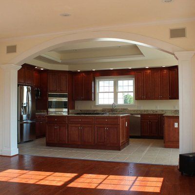 an empty kitchen with wooden cabinets and stainless steel appliances in the middle of the room