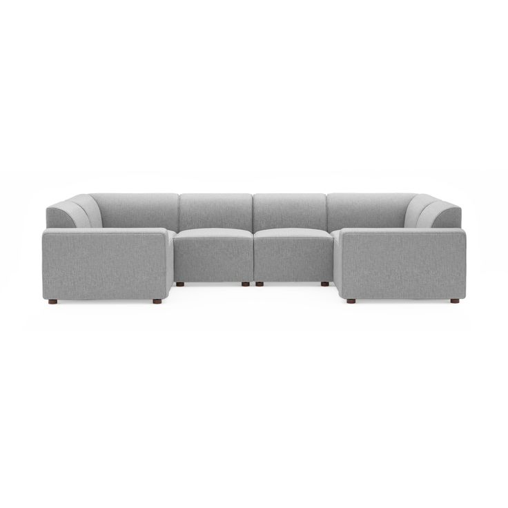 a gray sectional couch sitting on top of a white floor