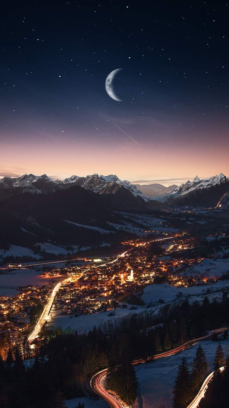 the night sky is lit up with bright lights and snow on the ground, as seen from above