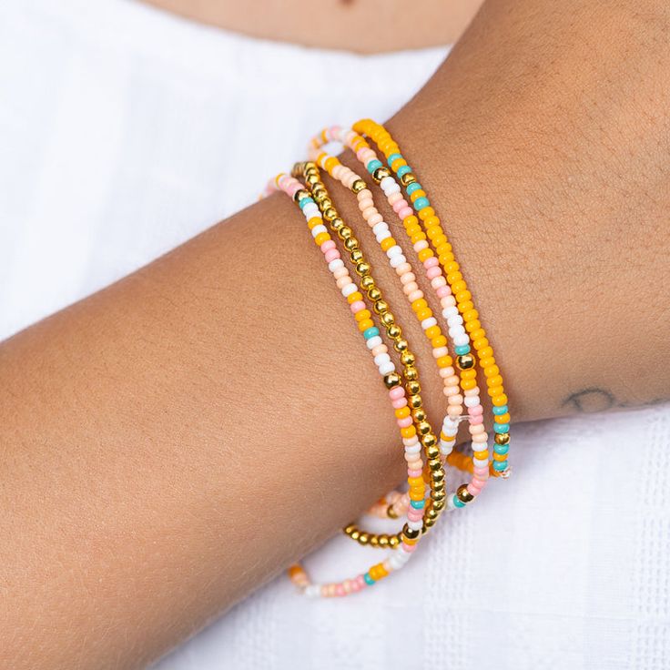 Get ready to rock the ultimate summer look with the Tropical Bracelet! This playful bracelet is a burst of beachside fun, featuring a vibrant mix of orange, white, teal, and pink beads, all accented with gleaming gold-colored details. Perfect for adding a splash of tropical flair to any outfit, the Tropical Bracelet is your go-to accessory for an endless summer vibe. Get ready to shine and bring the island magic wherever you go! Matching necklace and earrings sold separately. Beach Bracelets With Gold Beads, Multicolor Beachy Bracelets For Beach Party, Beachy Multicolor Bracelets For Beach Party, Coral Round Beads Bracelets For Beach, Colorful Beaded Yellow Bracelets For Vacation, Coral Round Beaded Bracelets For Beach, Summer Gold Beads Bracelets For Beach, Coral Round Beads Bracelet For Beach, Trendy Orange Friendship Bracelets For Beach