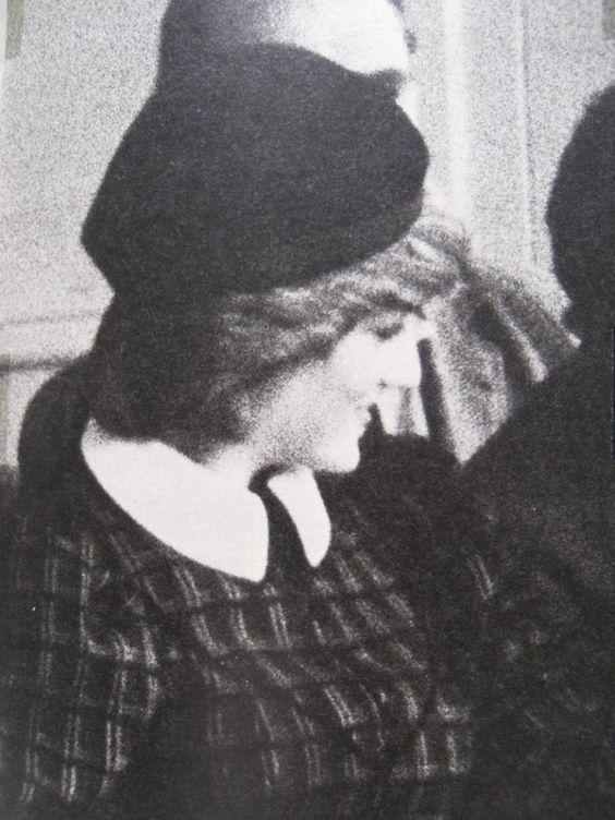 an old black and white photo of a woman wearing a hat