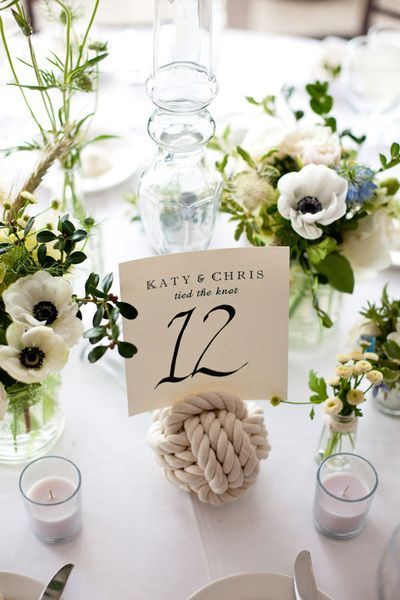 the table is set with white flowers and place cards