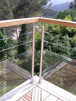 a balcony with glass railings and trees in the background