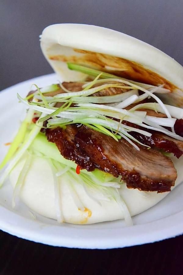 a white plate topped with meat and veggies on top of lettuce