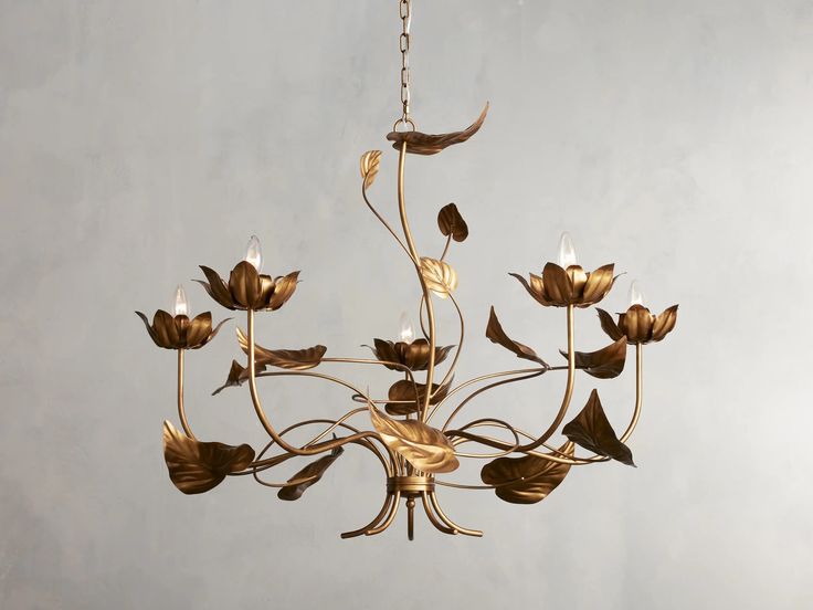 a gold chandelier with flowers hanging from it's center and leaves on the bottom