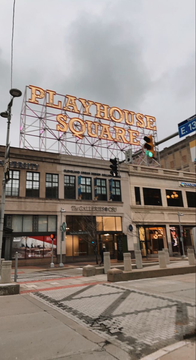 a large sign on top of a building that says play house square in front of it