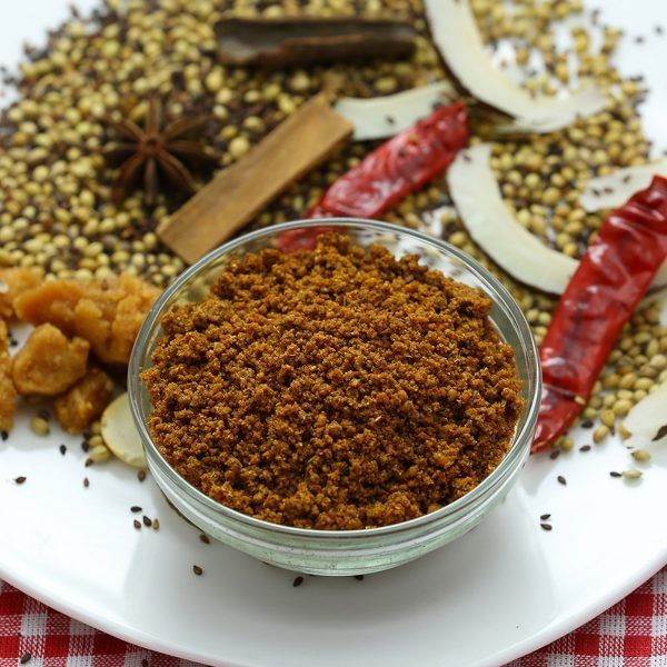 an assortment of spices and seasonings on a white plate with a red checkered table cloth