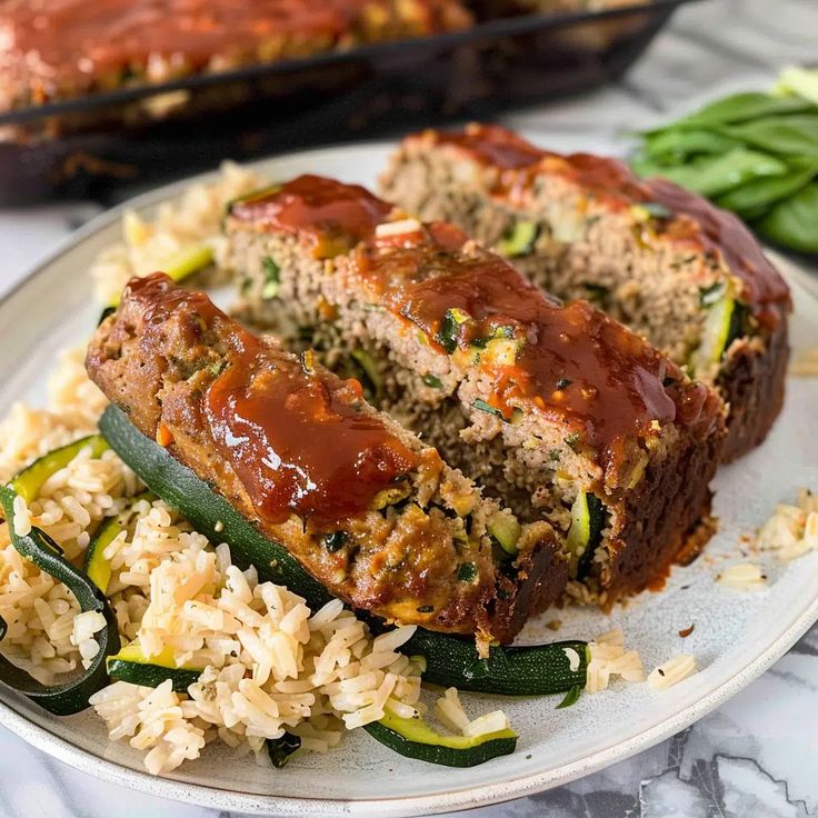 meatloaf and rice on a white plate with green peppers next to the dish