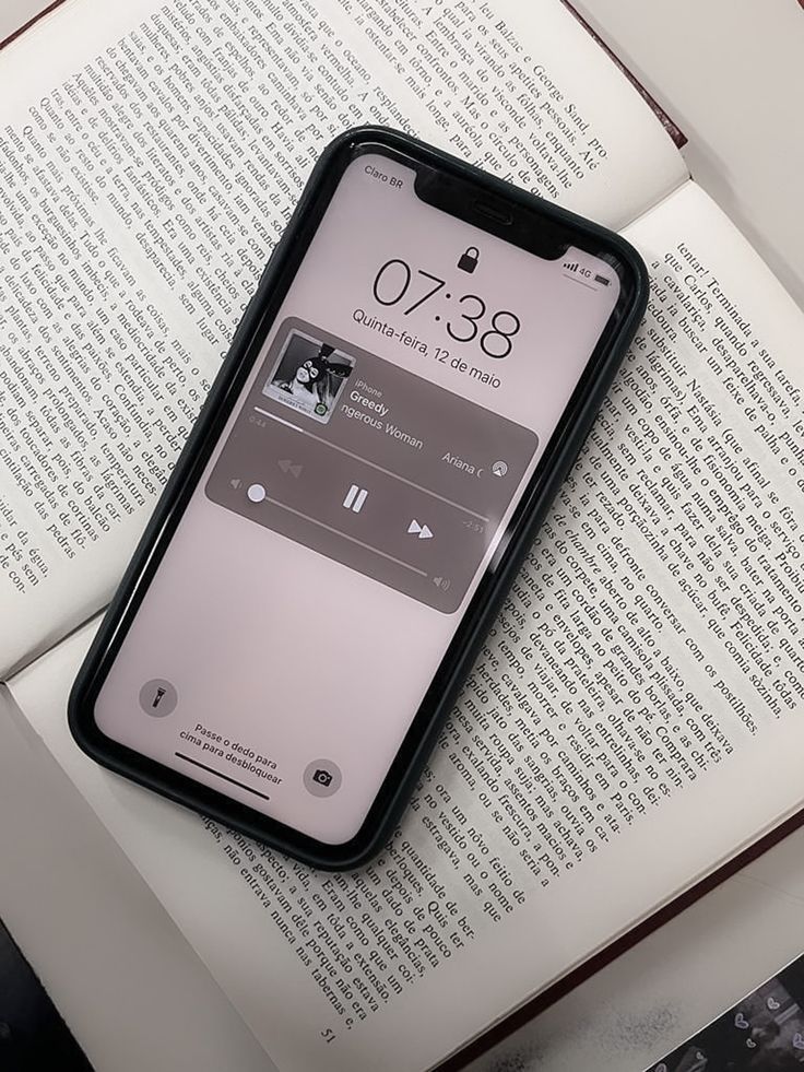 an iphone sitting on top of an open book