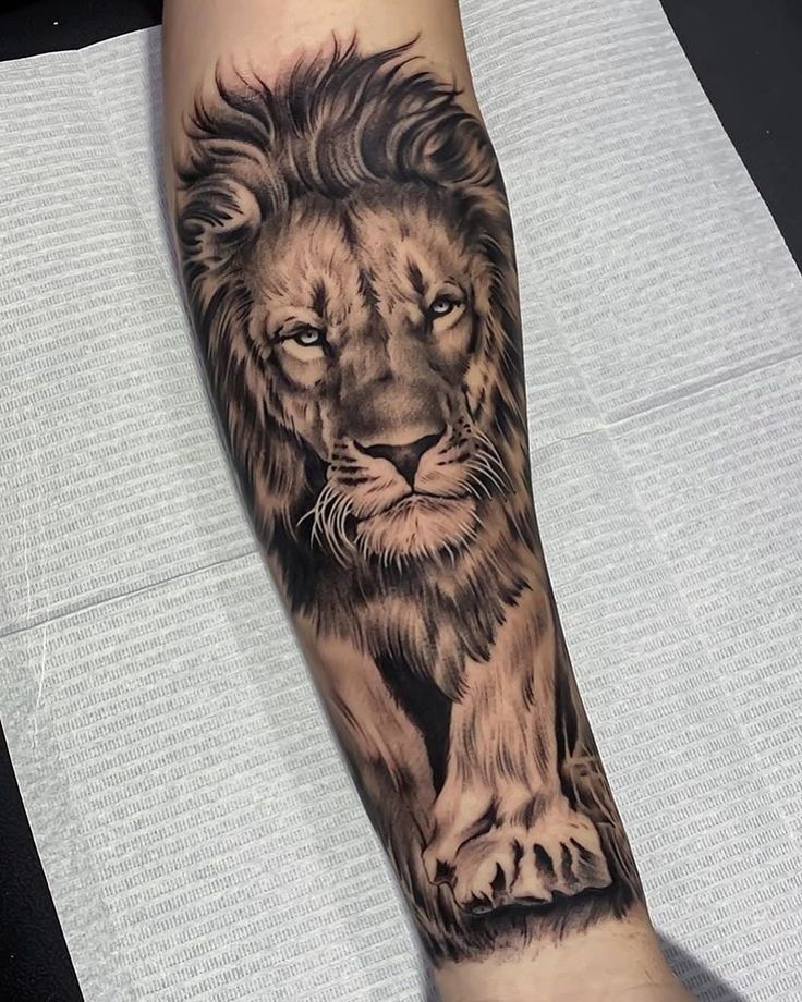 a man's arm with a lion tattoo on it