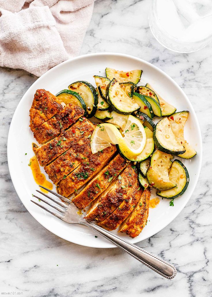 grilled chicken with zucchini and squash on a white plate