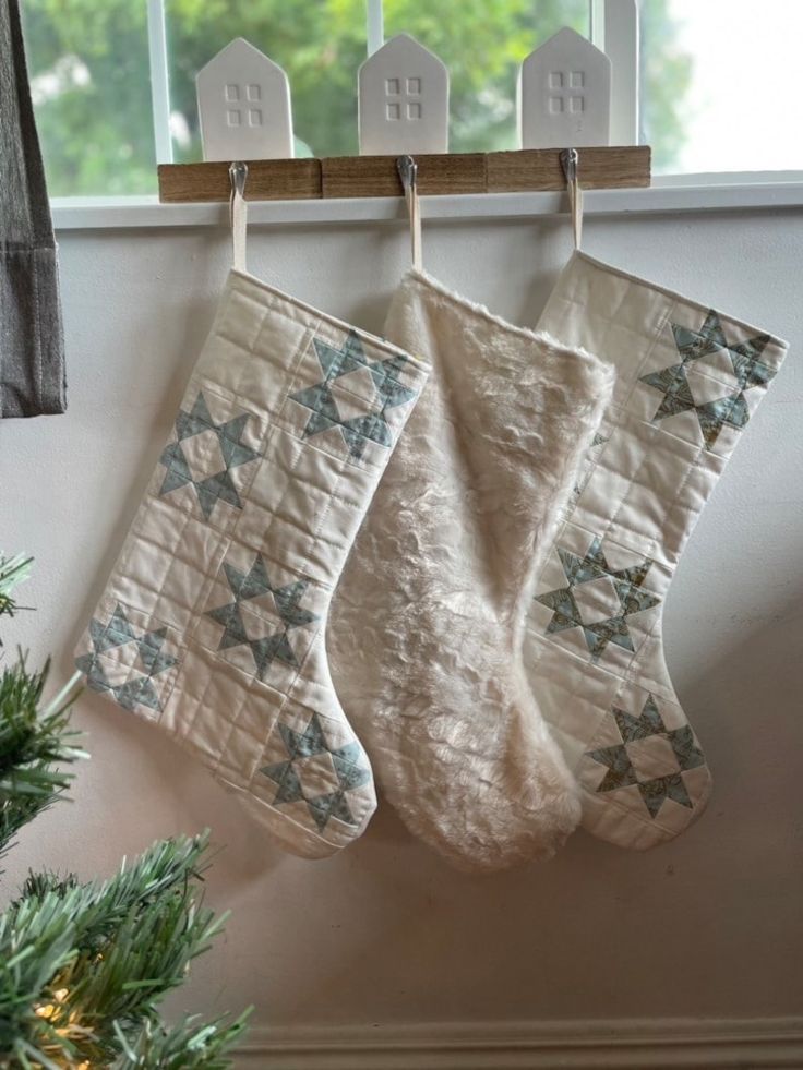 two christmas stockings hanging from a window sill