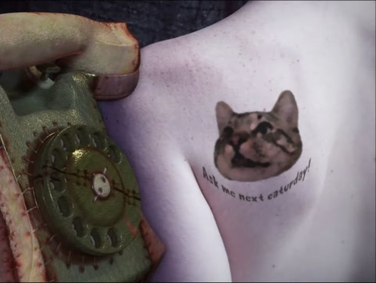 a close up of a person's arm with a cat tattoo on the shoulder