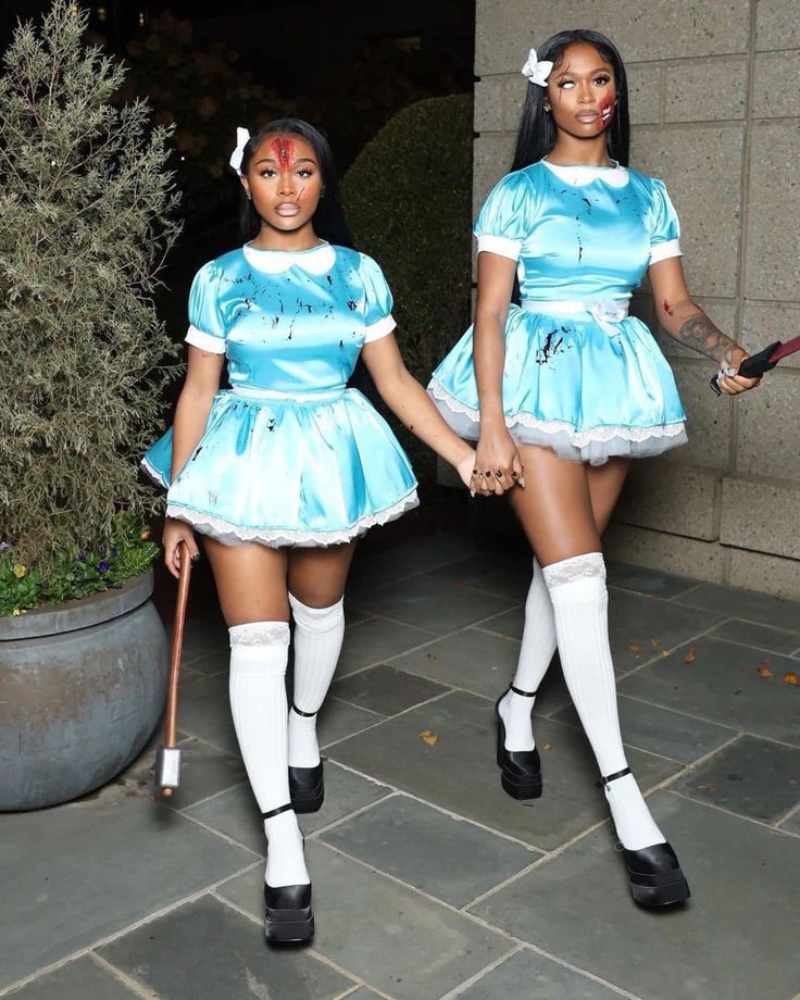 two women dressed in costumes holding hands