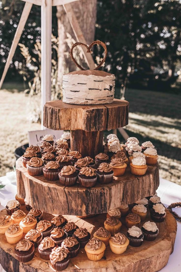 a three tiered cake with cupcakes on it