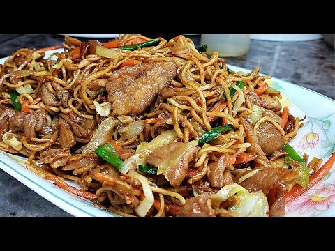 a white plate topped with meat and noodles