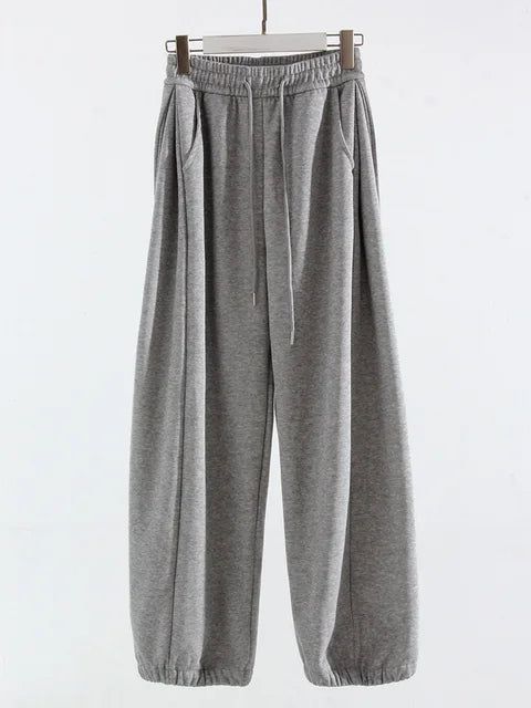 Elevate your comfort with our High-Waisted Sports Oversized Sweatpants. Made from a blend of cotton and polyester, they offer softness and durability. Their high waist and loose fit create a flattering and relaxed silhouette, while their solid pattern and flat front style exude casual elegance. With an elastic waist closure and functional pockets, they combine practicality with style. Perfect for leisure or workouts, these full-length sweatpants are a must-have addition to your wardrobe. Designe